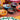 A group of colorful hand-painted ceramic bowls arranged on a table runner, surrounded by other decorative plates and glassware.